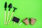 Home gardening. Miniature gardening tools: scoop, rake, inscription board and chalk, paper pots for planting on green cardboard.