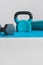 Home gym concept, blue yoga mat with kettlebell foam roller and dumbbell shot at shallow depth of field from low perspective