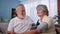 home health check, mature man controlling blood pressure of wife using tonometer, portrait happy elderly couple