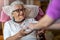 Home healthcare nurse gives a senior female a cup of hot tea