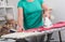 Home helper ironing clothes for an old woman