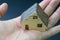 Home / house, real estate or residential concept, miniature ceramic house in real human female hand with dark background