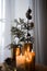 Home hygge with golgen candles and pine trees. Christmas time. Lifestyle cozy home