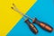 Home improvement: two screwdrivers philips and slotted on a blue and yellow flat lay background with copy space