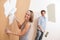 Home improvement: Young couple painting wall