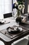 Home Inerior with dining room table setting with gold stainless tableware black cutlery setting on nartual marble top / interior