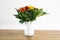 Home interior decor, bouquet colorfol in a white vase and white wall on a wooden table background modern decoration for