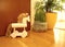 Home interior with green houseplants, wooden surfaces and a decoration in shape of white horse made from wood and natural material