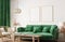 Home interior with poster frame mockup, green comfortable sofa on white wall with wooden furniture