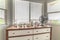 Home interior with potted cacti and electric fan on cabinet against bay window