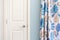 Home interior showing  colonial closet door with blue curtain decor and light blue painted wall