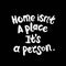 Home isn`t a place it`s a person. White letters on chalkboard background. Modern Brushed Lettering. Decorative lettering. Quote.