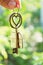 Home key with love house keyring hanging with blur garden background