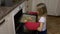 Home kitchen young girl in red mitts take tray with ginger cookies from oven. Hot biscuits from oven. Hand made meal