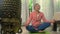 Home lifestyle - beautiful and happy mature woman with gray hair on her 50s doing yoga meditation exercise at Asian deco bedroom