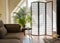 Home living room with wood and paper divider screen blocking sun from window, black metal accent table and sofa.