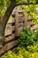 Home made bee hotel, in Dutch garden, mounted on a typical wooden garden fence. Bee hotels are places for solitary bees to make