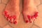 Home made cosmetology. Pedicure of aged woman. Feet with toe divider close up image. Slightly wrinkled skin, valgus, distended