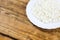 Home made large cottage cheese on white plate on wooden background. Plate on the right at photo.