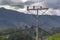 Home-made power pole with wires and old insulators against the backdrop of mountains and sky
