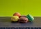 Home made still life with green plain background and coloured macaroons