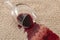 Home mishap and domestic accident concept with close up of  a spilled glass of red wine on brown carpet