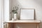 Home office concept. Empty horizontal wooden picture frame mockup. Cup of coffee on wooden table. White wall background