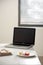 Home office desk with blank screen laptop, beautiful hortensia bouquet, macaron in front near window. Blog, website or social