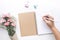 Home office desk table with woman hand,notepad,flower on white