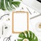 Home office workspace mockup with laptop, tropical leaves Monstera, clipboard, notebook and accessories on white