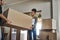 Home owner couple moving boxes into new home looking cheerful or excited inside their real estate house or living room