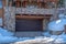 Home in Park City Utah with garage door framed by stone wall and wooden logs