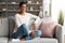 Home Pastime. Cheerful Young African American Woman Relaxing In Living Room