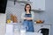 Home portrait of mature woman housewife in apron in kitchen