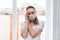 Home quarantine. Caucasian woman on sick leave in a medical protective mask, calls the phone, calls an ambulance. Poor health,