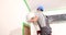 Home renovation and renovation and a worker cleans wall with sandpaper and prepares surface for painting
