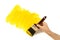 Home repairs : unfinished partly painted yellow wall, man holding paintbrush. Copy space.