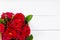 Home roses in a wooden box on a white wooden table flat lay. With copy space