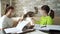 Home schooling girls in masks playing with cat instead of doing homework