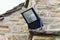 Home security light mounted on the corner of a rural stone cottage