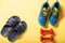 Home slippers and sports shoes. Sports shoes and dumbbells on a yellow mat