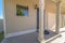 Home with small concrete porch in front of brown wooden door and shiny window