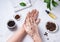 Home spa care for the skin of hands and nails. A young woman does a hand massage with a homemade coffee scrub with olive oil on