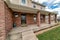 Home with spacious open porch and red brick exterior wall at the facade