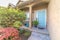 Home with stairs that leads to arched porch and blue front door with sidelight