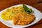 Home-style fried potatoes and a large piece of meat on a white plate. Curly chopped green cucumber.