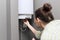 Home water heater, woman regulates the temperature on an electric water heater