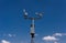 Home weather station on a background of blue sky with the sun behind the clouds. Measurement of temperature, humidity and wind dir