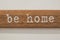 Home wording design on wooden white wall. Home is the starting place of love,