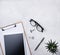 Home work. Business flat lay with note, pencil, eye glasses, tablet and cucculent, on white beton background